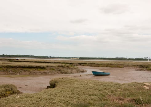 single deserted boat in mud of landscape harwich felixstowe essex england uk