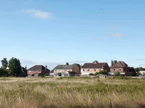 back of houses in a field in summer light wivenhoe essex england uk