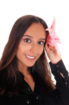 A closeup portrait image of a East Indian woman in a black blouse.holding a pink lily to her head, isolated for white background..