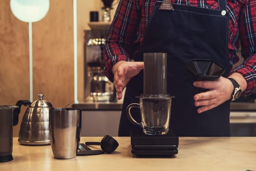 Barista brewing coffee in aeropress in the cafe