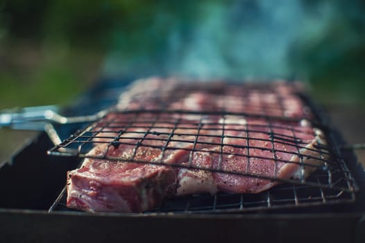 Grilling pork entrecote meat on a grill