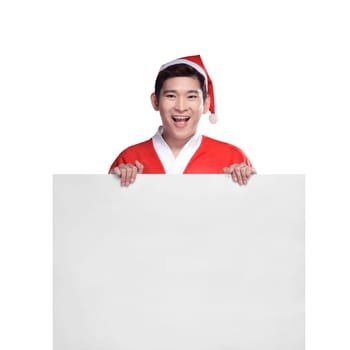 Young man in Santa Claus costume behind white board with space for text over white background