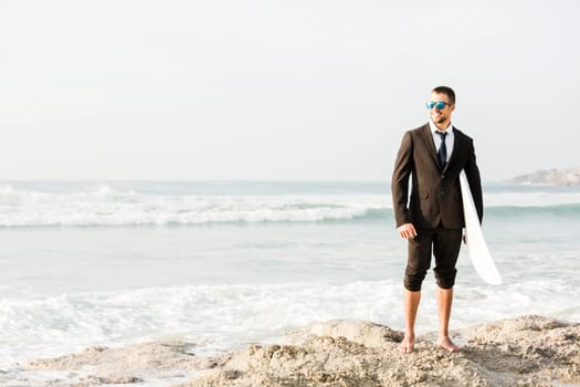 A Businessman holding is surfboard after a long day of work