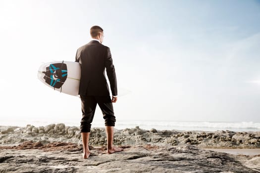 A Businessman holding is surfboard after a long day of work