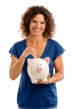 Portrait of a happy middle aged woman puting some money on a Piggybank