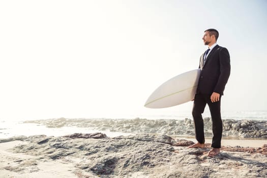 A Businessman holding is surfboard after a long day of work