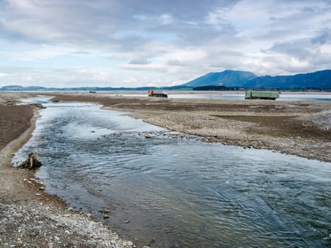 Course of the river Lech in the drained Forggensee near Füssen / Bavaria. The Forggensee is fed by thawing snow from the high Alps and is a reservoir for sedimentary rocks. In spring,the lake is emptied to remove the sedimentary rock. In summer,the lake has returned to its normal water level and is navigated by excursion boats.