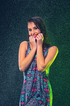 Young beautiful woman with splash of rain. Studio shot