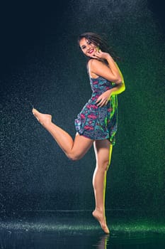 Young beautiful woman with splash of rain. Studio shot