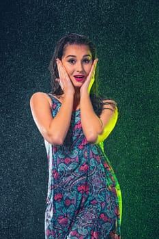 Young beautiful woman with splash of rain. Studio shot