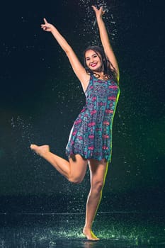 Young beautiful woman with splash of rain. Studio shot