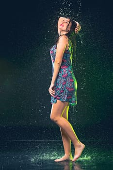 Young beautiful woman with splash of rain. Studio shot