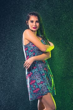 Young beautiful woman with splash of rain. Studio shot