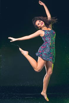 Young beautiful woman with splash of rain. Studio shot