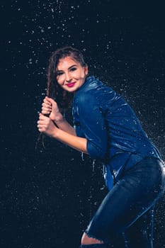 Young beautiful woman with splash of rain. Studio shot