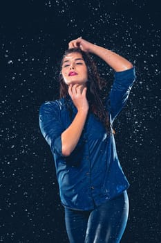 Young beautiful woman with splash of rain. Studio shot
