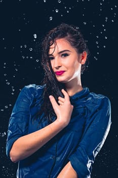 Young beautiful woman with splash of rain. Studio shot