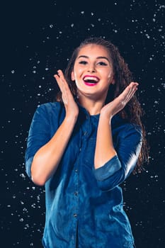 Young beautiful woman with splash of rain. Studio shot