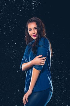 Young beautiful woman with splash of rain. Studio shot