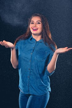 Young beautiful woman with splash of rain. Studio shot
