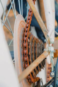 Old rusty chain on white bicycle. Selective focus close up.