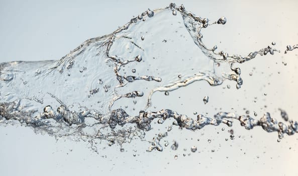 Splashes of water in the air against a bright background