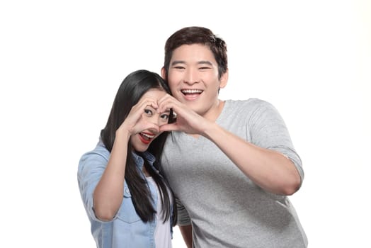 Closeup of couple making heart shape with hands isolated over white background