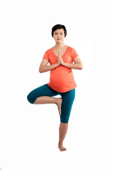 Asian pregnant woman doing yoga over isolated white background