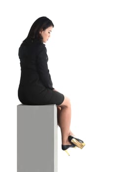 Asian business woman sitting on the block isolated over white background