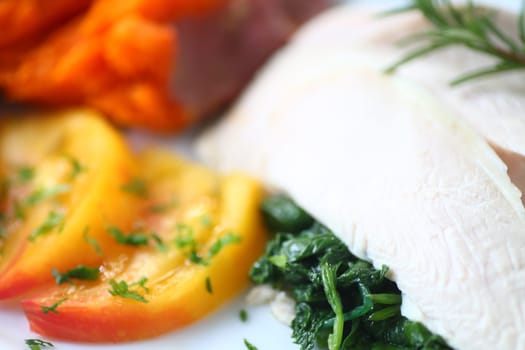 Poached chicken slices over sauteed baby kale with sweet potato and tomato