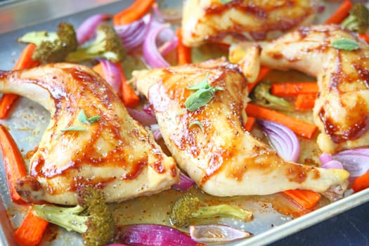 Chicken quarters roasted with carrots, onions and broccoli on sheet pan
