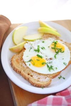 Two fried eggs on buttered toast with coarse salt and apple slices