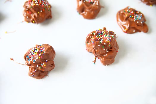 Chocolate nut clusters with colorful sprinkles and copy space