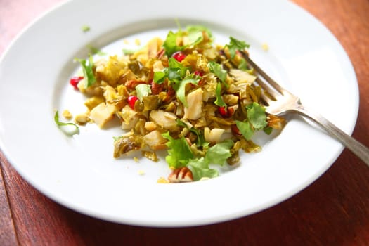 Chopped brussels sprouts with baby lettuces, pecans and pomegranate seeds