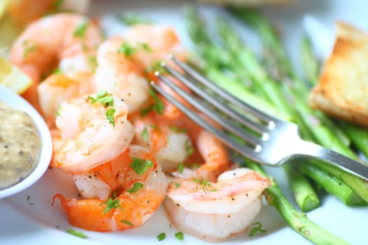 Closeup of shrimp dinner with asparagus, garlic bread and a grainy mustard and mayo sauce