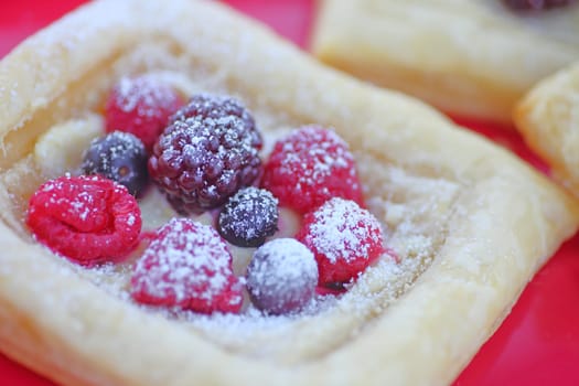 Puff pastry topped with fresh blueberries, raspberries and blackberries sprinkled with powdered sugar
