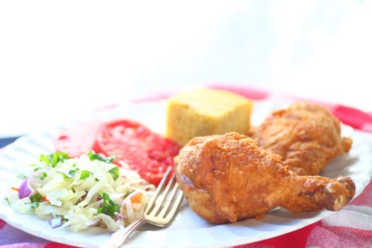 Fried chicken with coleslaw, tomatoes and cornbread with room for text