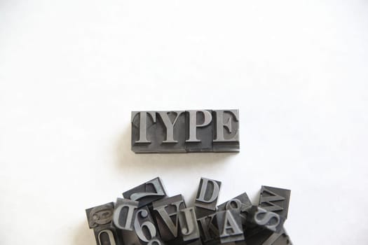 The word type in metal letters with a pile of assorted letters and numbers underneath