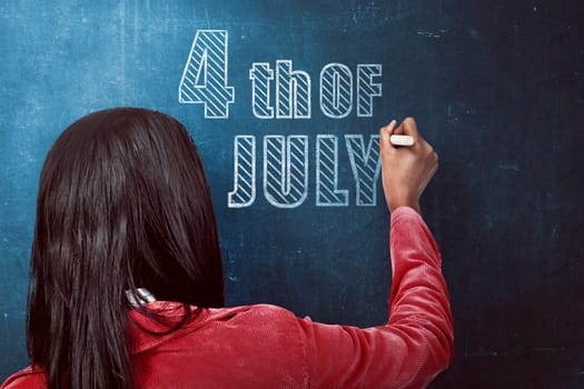 Woman write 4th of july on the chalkboard. Independence day concept