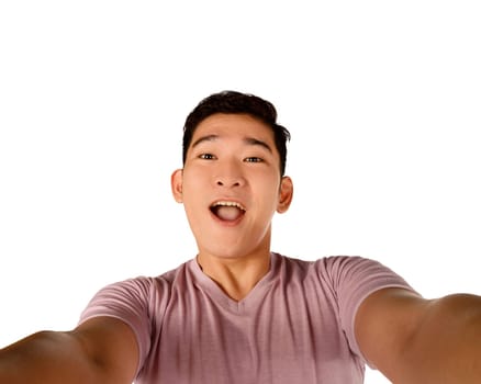 Handsome young man holding camera and making selfie isolated over white background