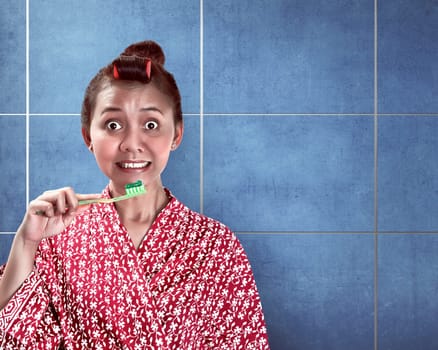 Asian woman brushing her teeth on the bathroom
