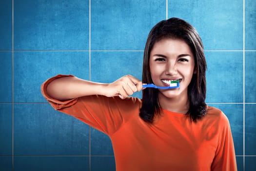 Asian woman brushing her teeth on the bathroom