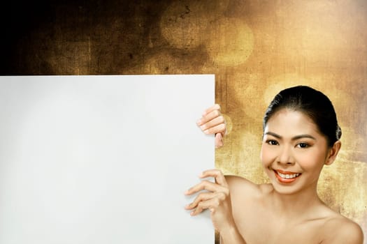 Pretty asian woman holding blank banner over blur background