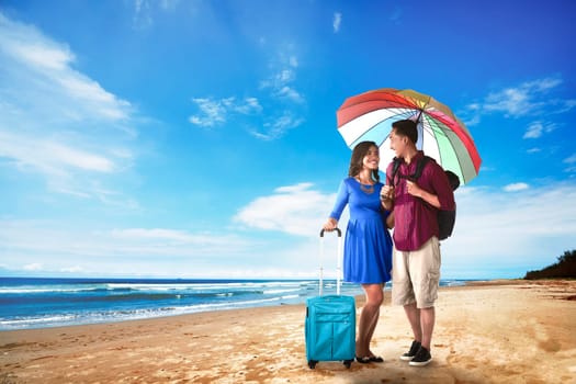 Couple asian tourist standing on the beach with blue sky background