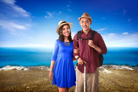 Couple asian tourist standing on the beach with blue sky background