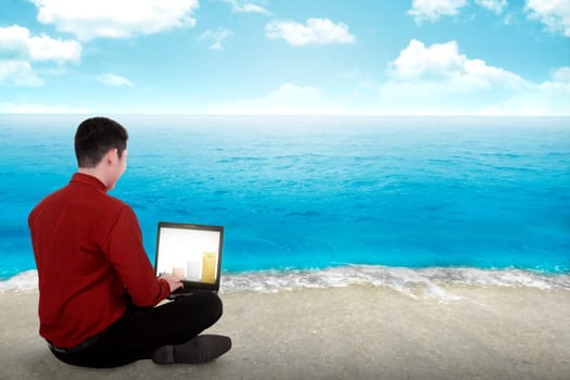 Business man working on the beach with blue sky background