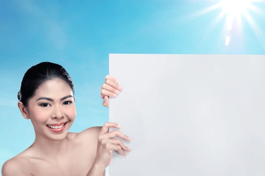 Pretty asian woman holding blank banner over blur background