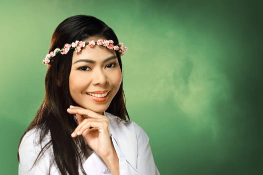 Pretty asian woman wearing flower headband over blur background
