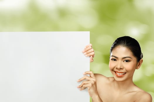 Pretty asian woman holding blank banner over blur background