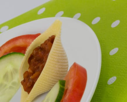 A small snack with tomato and stuffed mussel noodle.